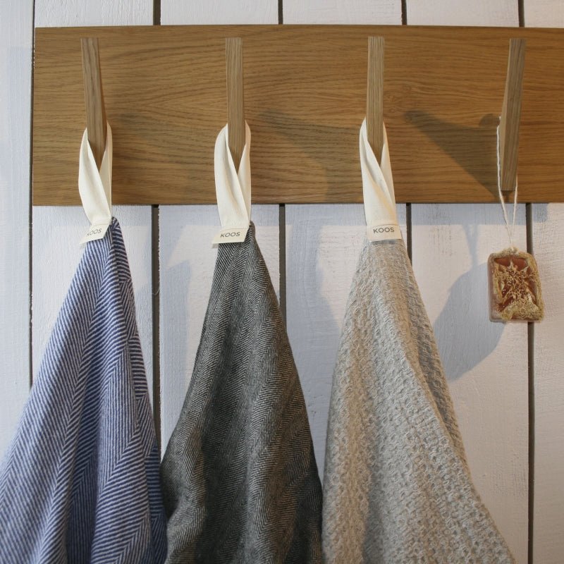 Bath towels in natural colours hanging on wooden hooks