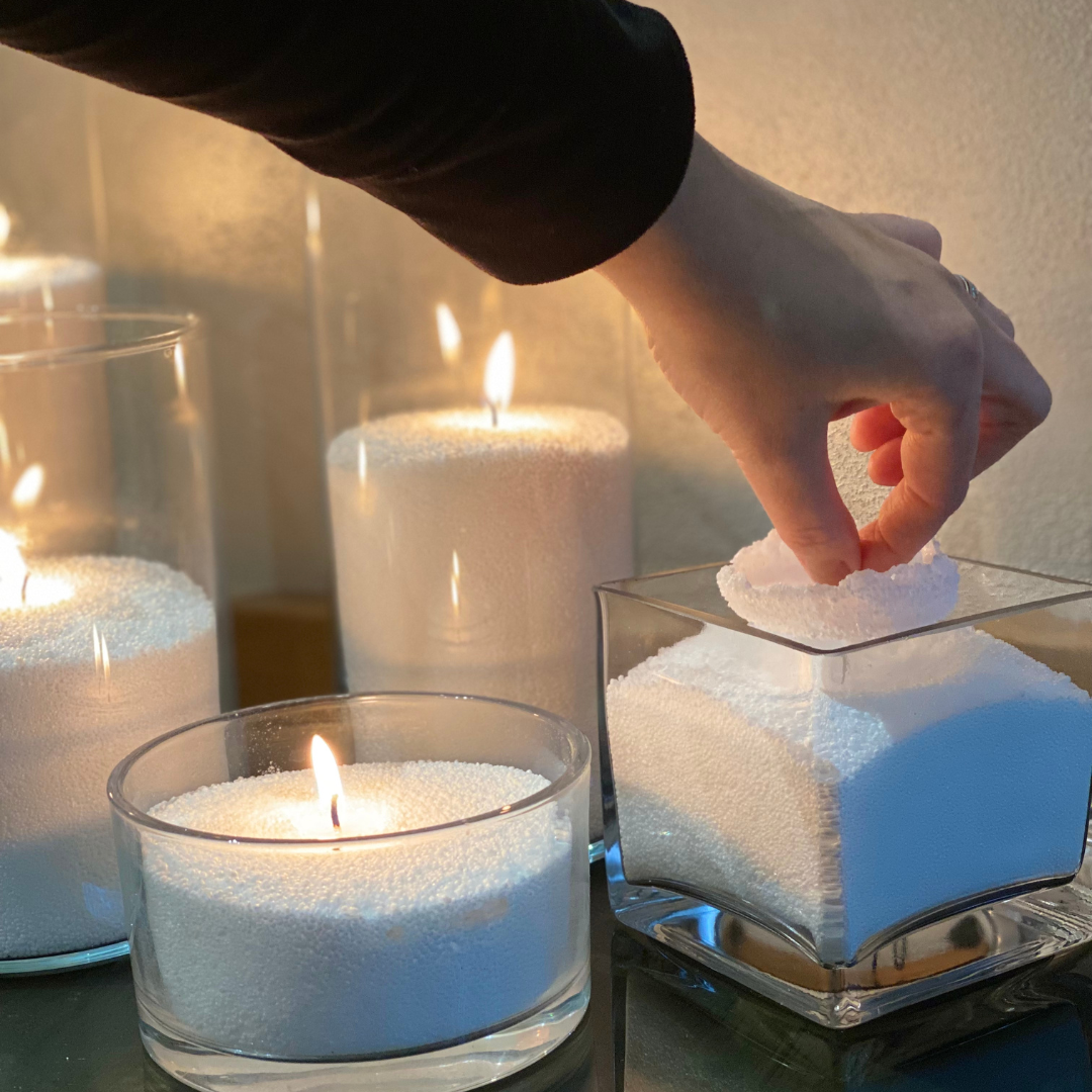 Adding a wick to a powdered candle in a glass container