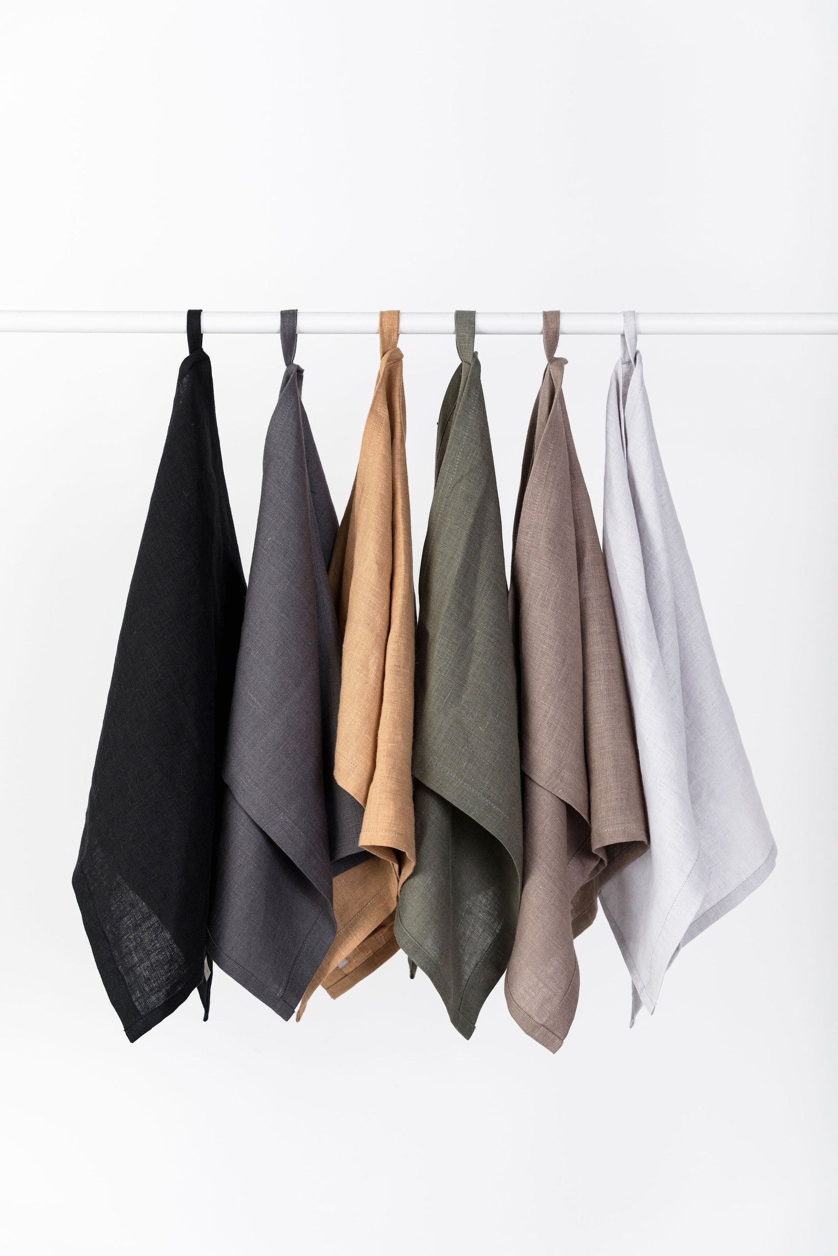 Linen kitchen towels in natural colours hanging from a rail