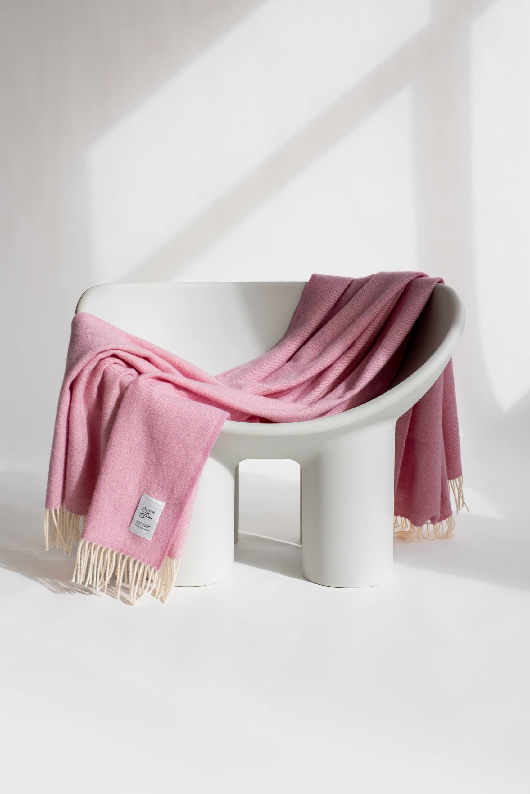 Mira wool throw in gift box draped over a lounge chair